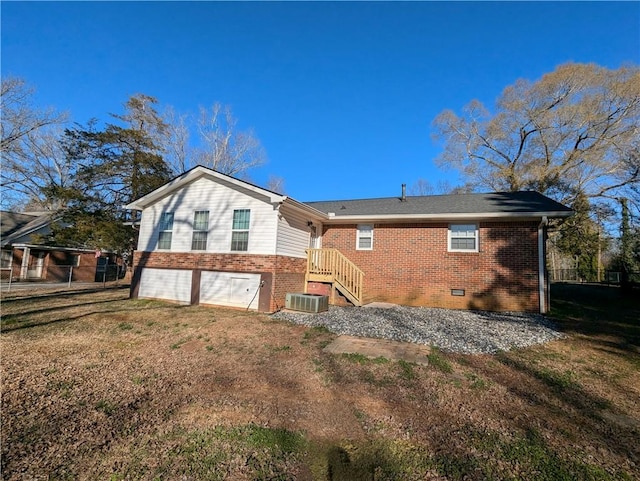 back of house featuring cooling unit, crawl space, brick siding, and a lawn