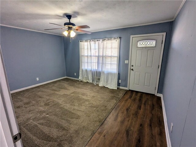 spare room with ceiling fan, baseboards, dark wood-style flooring, and ornamental molding