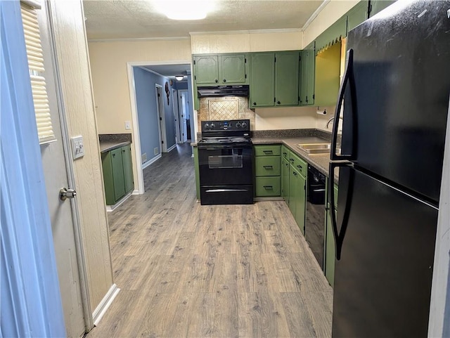 kitchen with black appliances, range hood, and green cabinetry