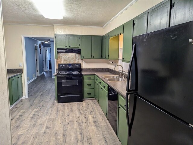 kitchen with ornamental molding, light wood-style floors, a sink, green cabinetry, and black appliances