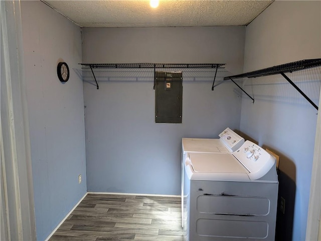 washroom featuring a textured ceiling, laundry area, wood finished floors, independent washer and dryer, and electric panel