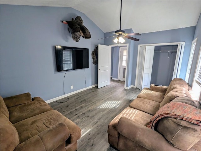 living room featuring vaulted ceiling, ceiling fan, wood finished floors, and baseboards