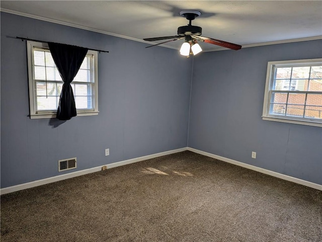 carpeted spare room featuring visible vents, ornamental molding, a wealth of natural light, and baseboards