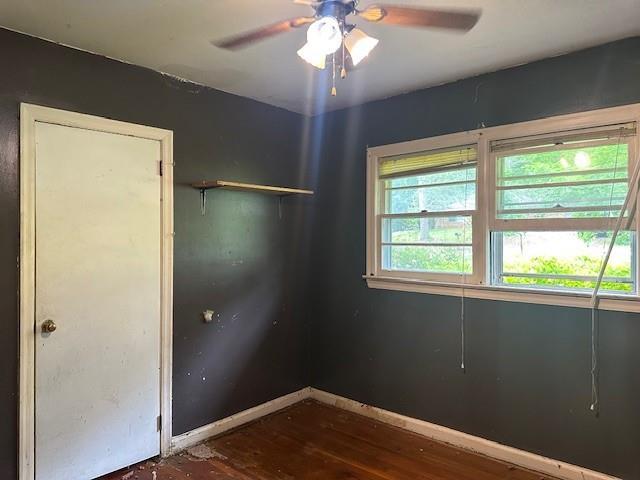 2588 Sandtown Rd SW, Marietta, GA 30060 - empty room with dark wood-style floors, a ceiling fan, and baseboards