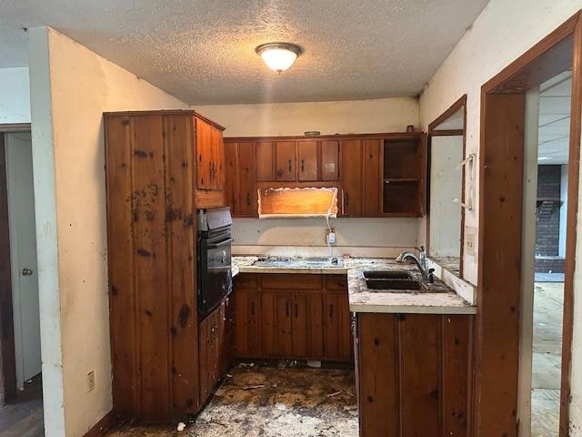 2588 Sandtown Rd SW, Marietta, GA 30060 - kitchen featuring black oven, a sink, stainless steel gas stovetop, a textured ceiling, and light countertops