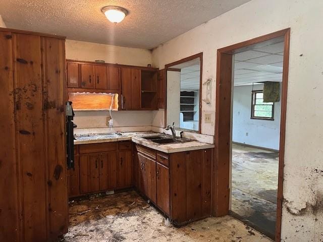 2588 Sandtown Rd SW, Marietta, GA 30060 - kitchen with a sink, a textured ceiling, light countertops, open shelves, and brown cabinetry