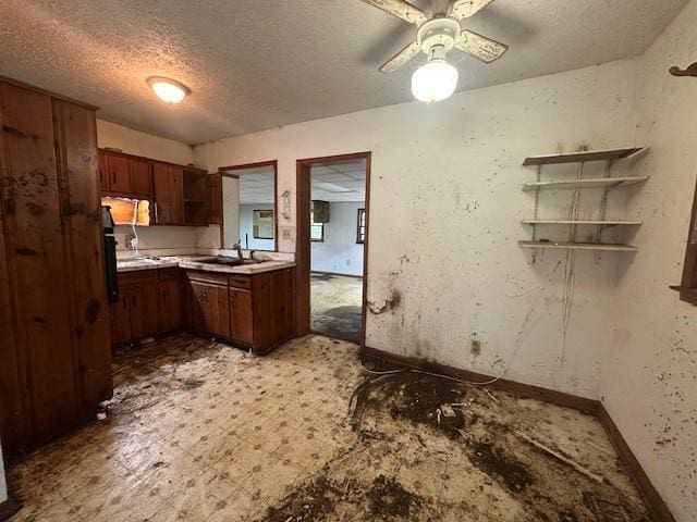 2588 Sandtown Rd SW, Marietta, GA 30060 - kitchen with baseboards, a textured ceiling, a sink, light countertops, and a ceiling fan