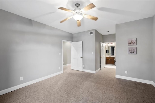 unfurnished bedroom with ensuite bath, ceiling fan, and light colored carpet