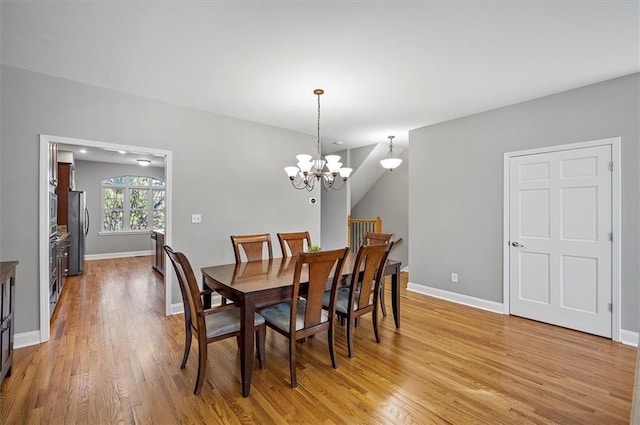 dining area featuring light wood-type flooring and an inviting chandelier