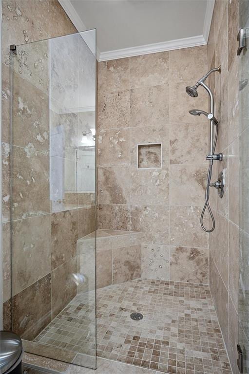 bathroom with a tile shower and crown molding