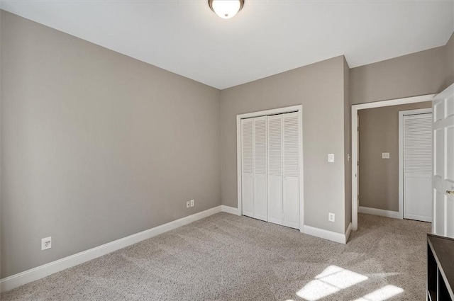 unfurnished bedroom with light colored carpet and a closet