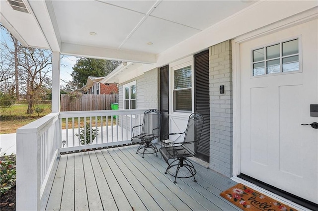 wooden deck with covered porch and visible vents