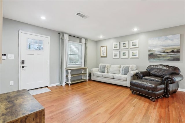 living area featuring baseboards, visible vents, wood finished floors, and recessed lighting