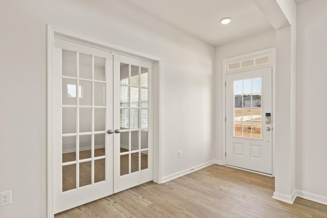 entryway with plenty of natural light, baseboards, wood finished floors, and french doors