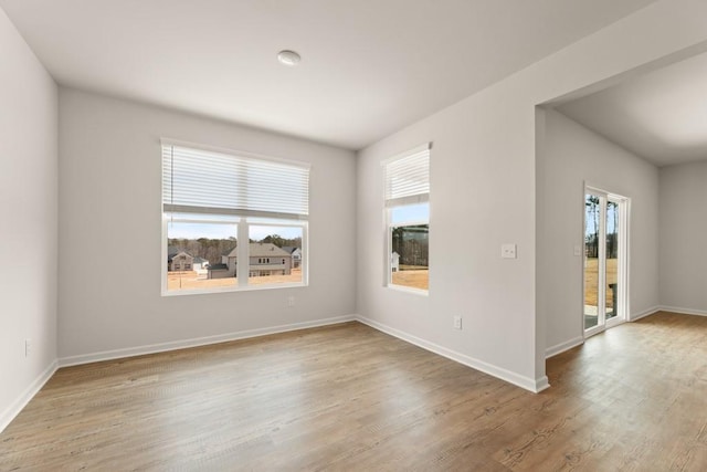 unfurnished room with baseboards and wood finished floors