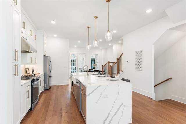 1032 Robert Smalls Way, Atlanta, GA 30318 - kitchen with stainless steel appliances, a center island with sink, under cabinet range hood, white cabinets, and recessed lighting