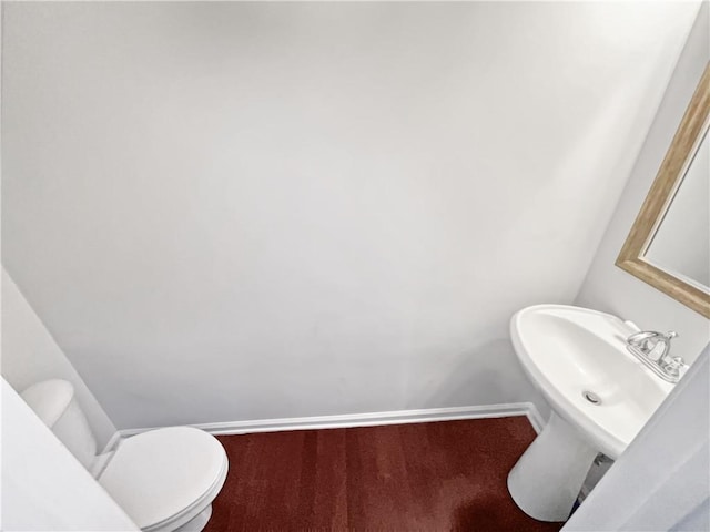 bathroom with toilet and baseboards