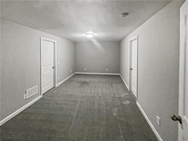 carpeted empty room featuring visible vents and baseboards