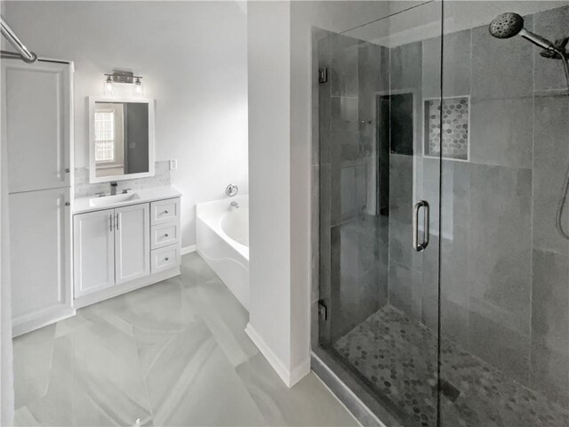 full bath featuring a stall shower, a garden tub, and vanity