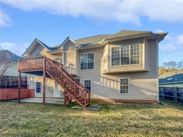 rear view of property with a lawn, stairway, a patio area, fence, and a wooden deck