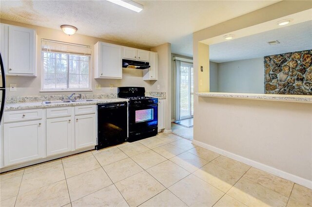 kitchen featuring sink, light tile patterned floors, light stone counters, white cabinets, and black appliances