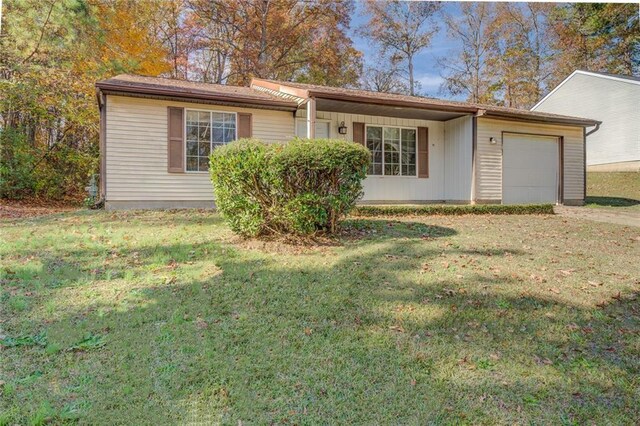 single story home featuring a front lawn and a garage