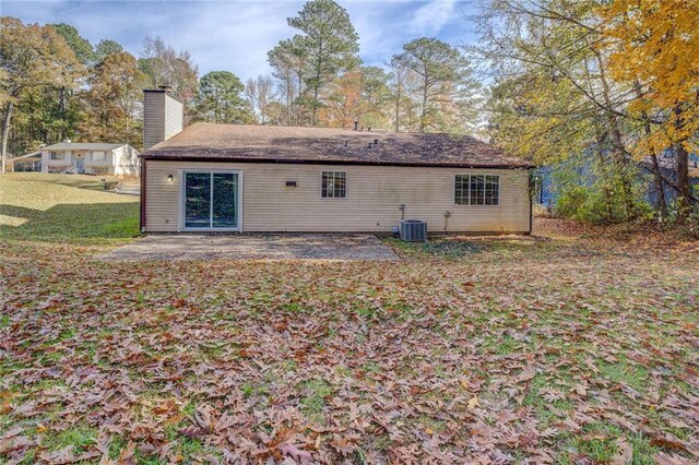 rear view of house with central air condition unit, a yard, and a patio