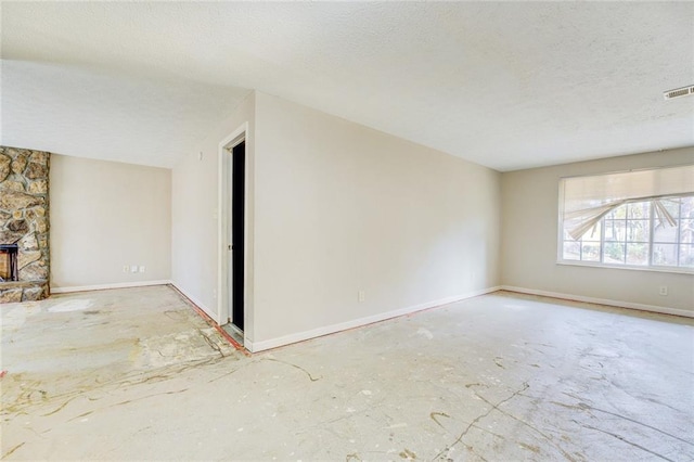 unfurnished living room with a fireplace and a textured ceiling