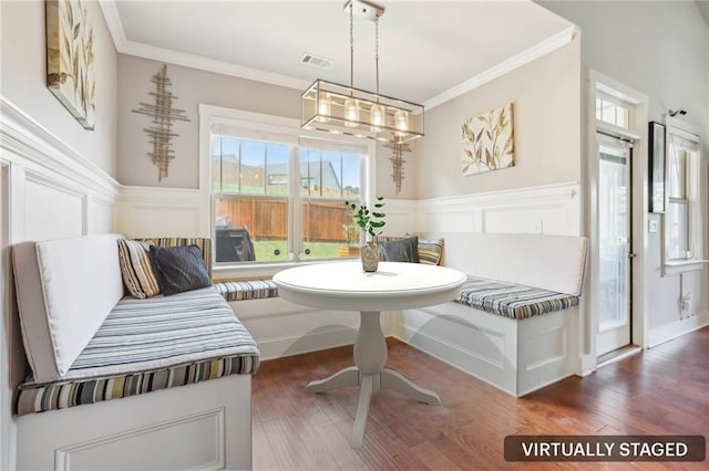 dining area featuring breakfast area, dark wood-style flooring, and crown molding