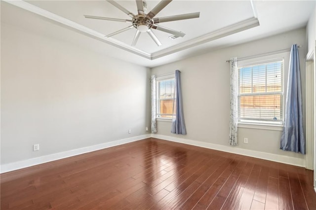 unfurnished room featuring a raised ceiling, a ceiling fan, and dark wood-type flooring