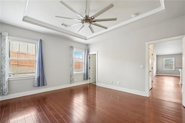 unfurnished room with visible vents, a raised ceiling, and a healthy amount of sunlight