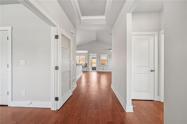 hall featuring baseboards, lofted ceiling, and wood finished floors