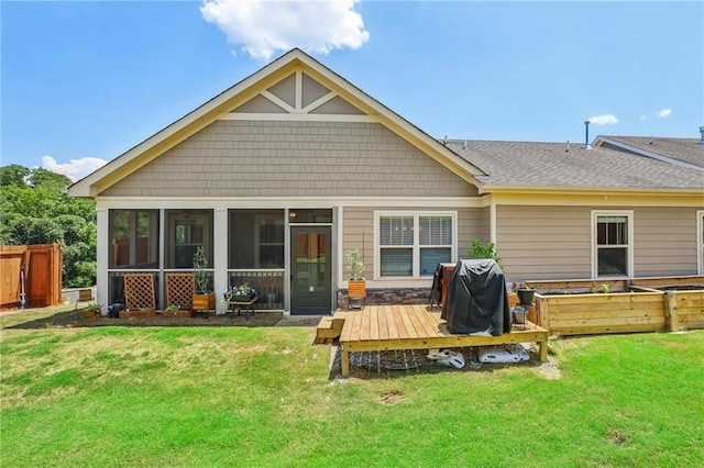 back of house with fence, a wooden deck, roof with shingles, a yard, and a sunroom