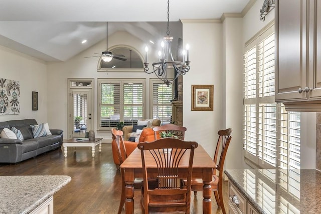 dining room featuring lofted ceiling, dark wood-type flooring, ceiling fan with notable chandelier, and crown molding