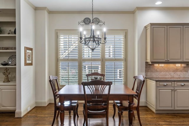 dining space featuring a notable chandelier, ornamental molding, and dark hardwood / wood-style flooring