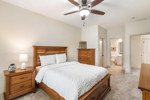 carpeted bedroom featuring ceiling fan and ensuite bath