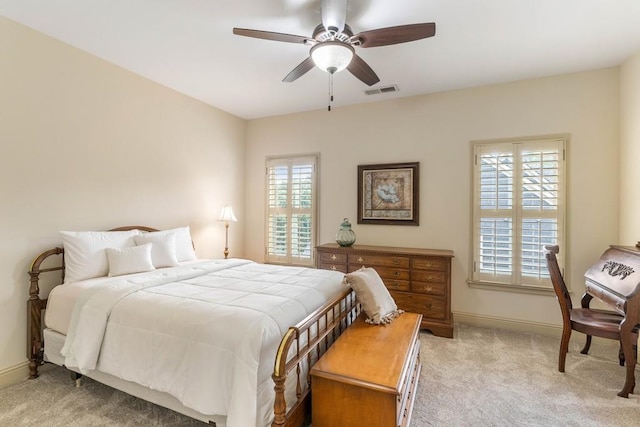 bedroom featuring multiple windows, light colored carpet, and ceiling fan