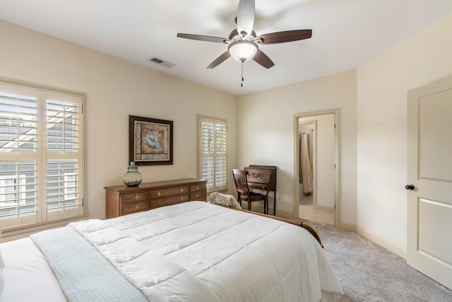 bedroom featuring ceiling fan, multiple windows, and light colored carpet