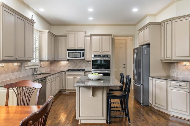 kitchen with dark hardwood / wood-style floors, backsplash, sink, a center island, and appliances with stainless steel finishes