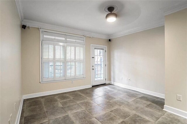 empty room featuring crown molding and baseboards