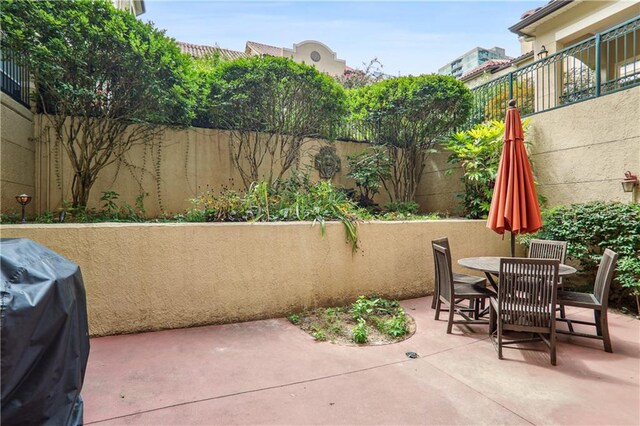 view of patio featuring area for grilling, outdoor dining area, and a fenced backyard