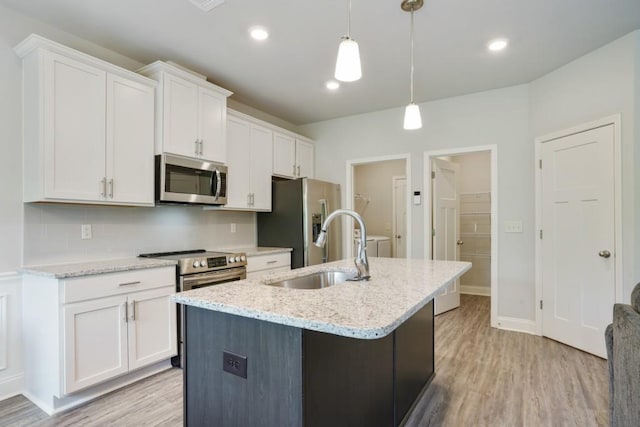 1360 Sugar Glen Ct, Lawrenceville, GA 30044 - kitchen with stainless steel appliances, a sink, light wood-style flooring, white cabinetry, and recessed lighting