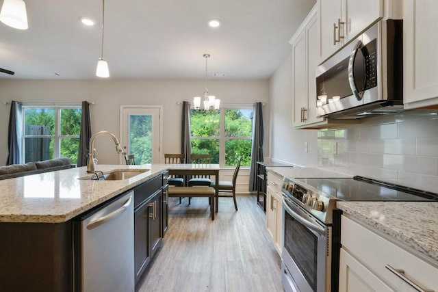 1360 Sugar Glen Ct, Lawrenceville, GA 30044 - kitchen featuring appliances with stainless steel finishes, a sink, light wood-style floors, decorative backsplash, and a chandelier