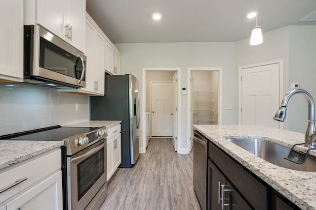 1360 Sugar Glen Ct, Lawrenceville, GA 30044 - kitchen with appliances with stainless steel finishes, a sink, white cabinetry, decorative backsplash, and light wood finished floors