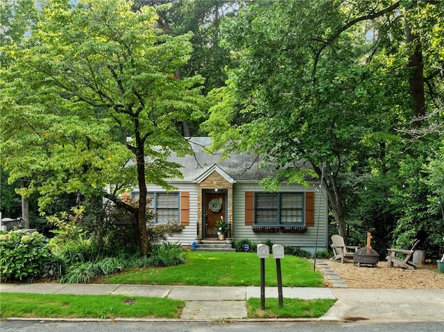 view of front facade featuring a front lawn and a fire pit