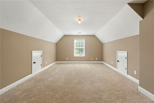 bonus room featuring light carpet and vaulted ceiling