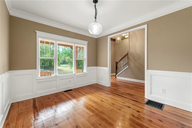 empty room featuring ornamental molding and wood-type flooring