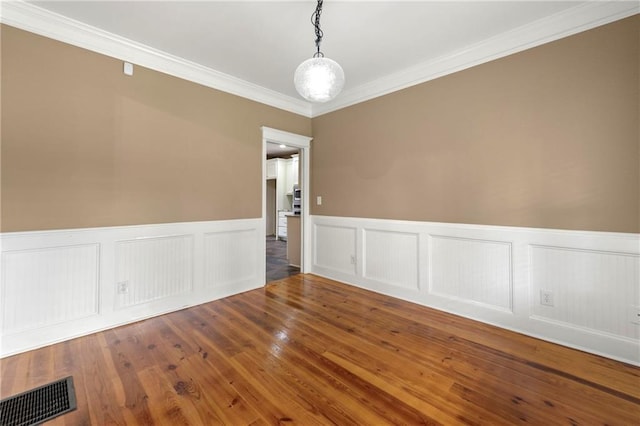 empty room with wood-type flooring and crown molding