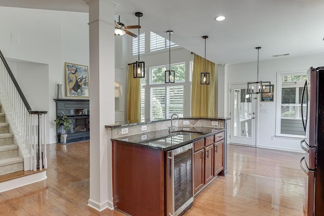 7405 Brookstone Way, Flowery Branch, GA 30542 - kitchen featuring beverage cooler, freestanding refrigerator, dark stone counters, light wood-type flooring, and ceiling fan