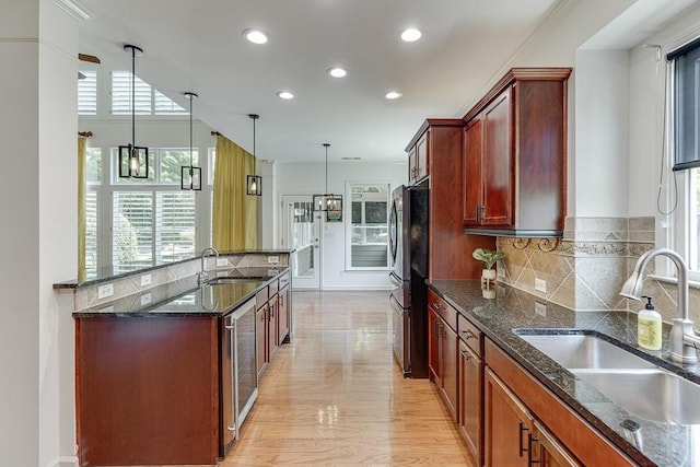 7405 Brookstone Way, Flowery Branch, GA 30542 - kitchen with healthy amount of natural light, recessed lighting, dark stone countertops, freestanding refrigerator, and backsplash